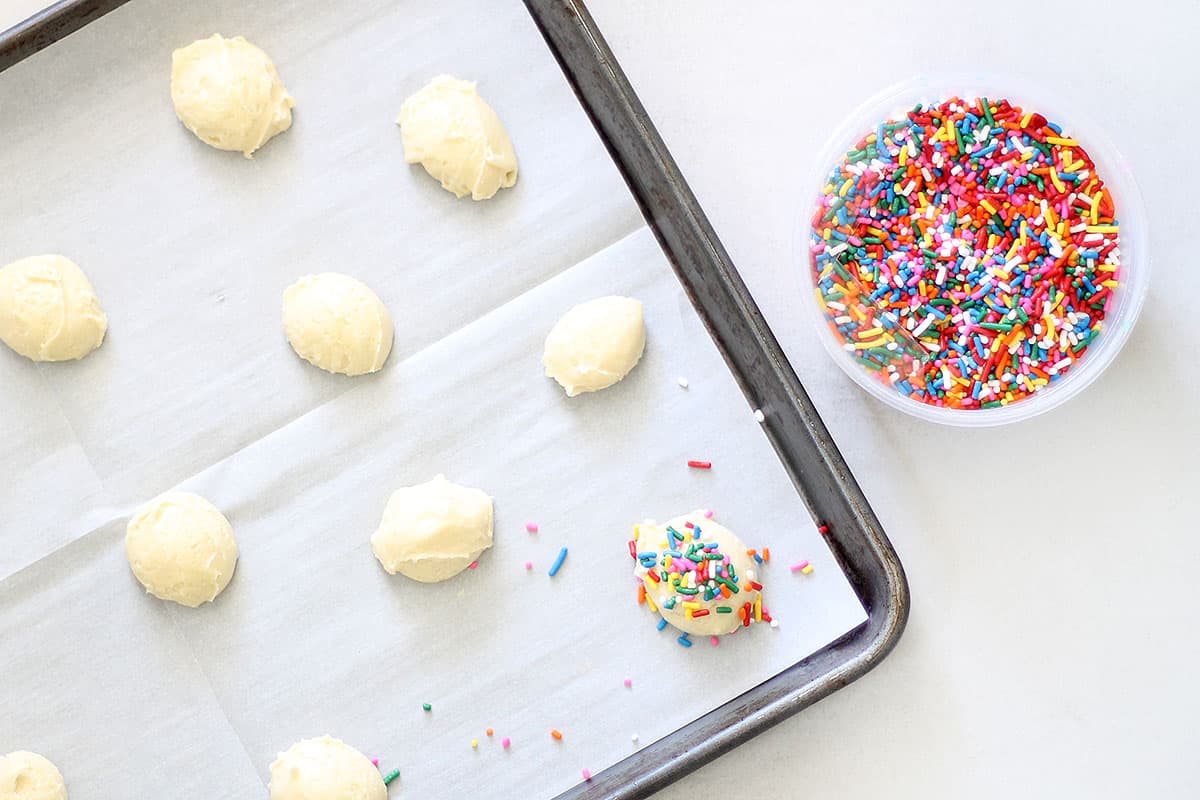 preparing 3-ingredient cake mix cookies with sprinkles on baking tray