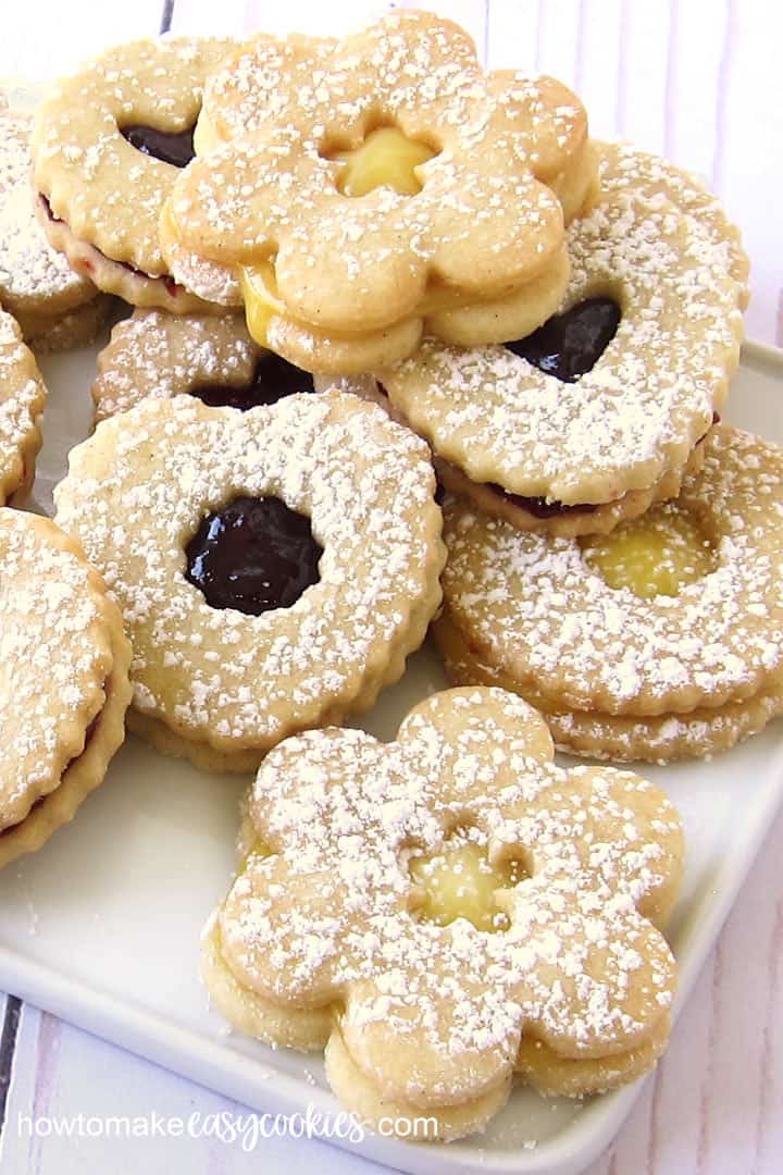 Daisy, heart, and round Linzer Cookies filled with lemon curd, raspberry jam, and chocolate spread.