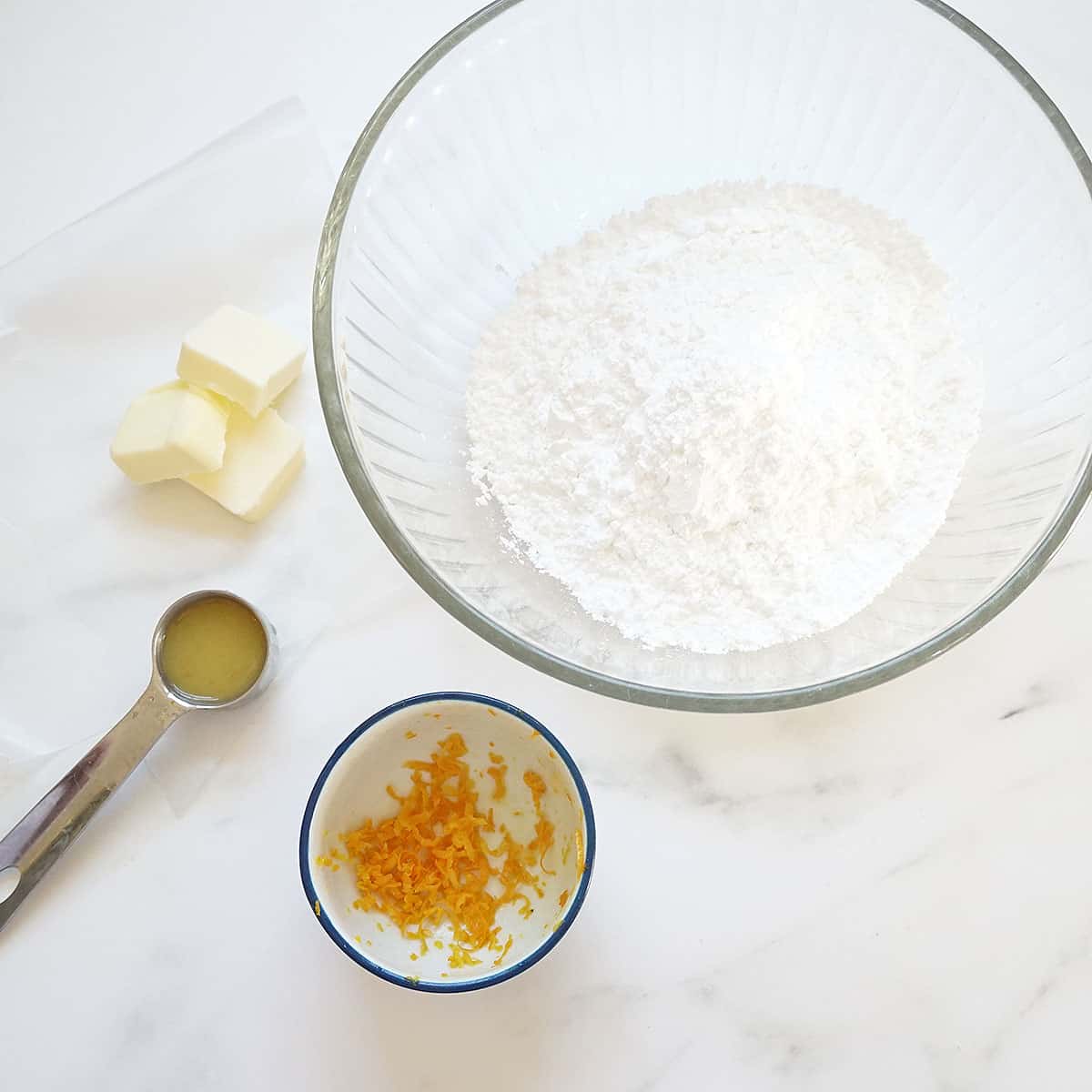 ingredients for orange butter icing: butter, orange juice, confectioner's sugar, orange zest 