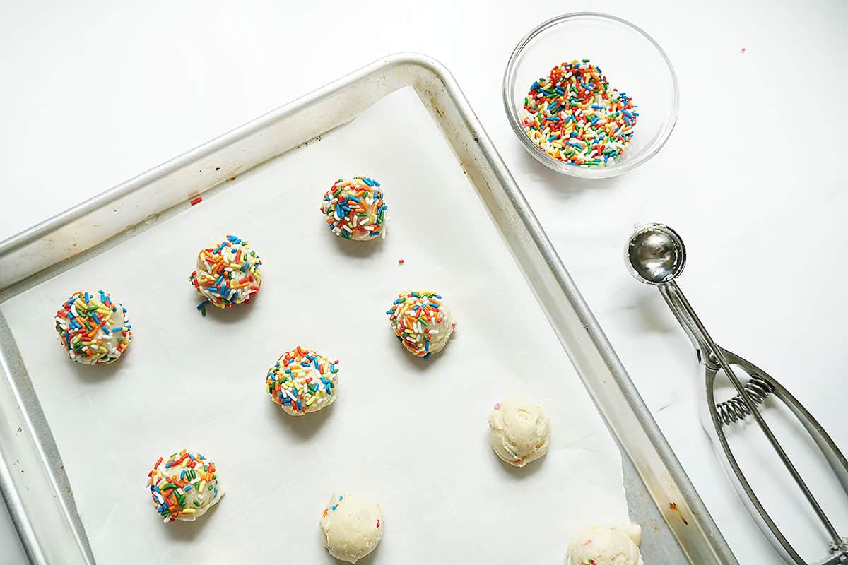 stacked Funfetti cake mix cookie dough on baking tray with sprinkles