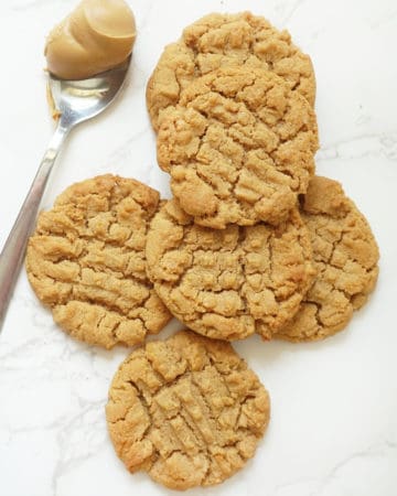 overhead view of flourless peanut butter cookies with spoon of peanut butter