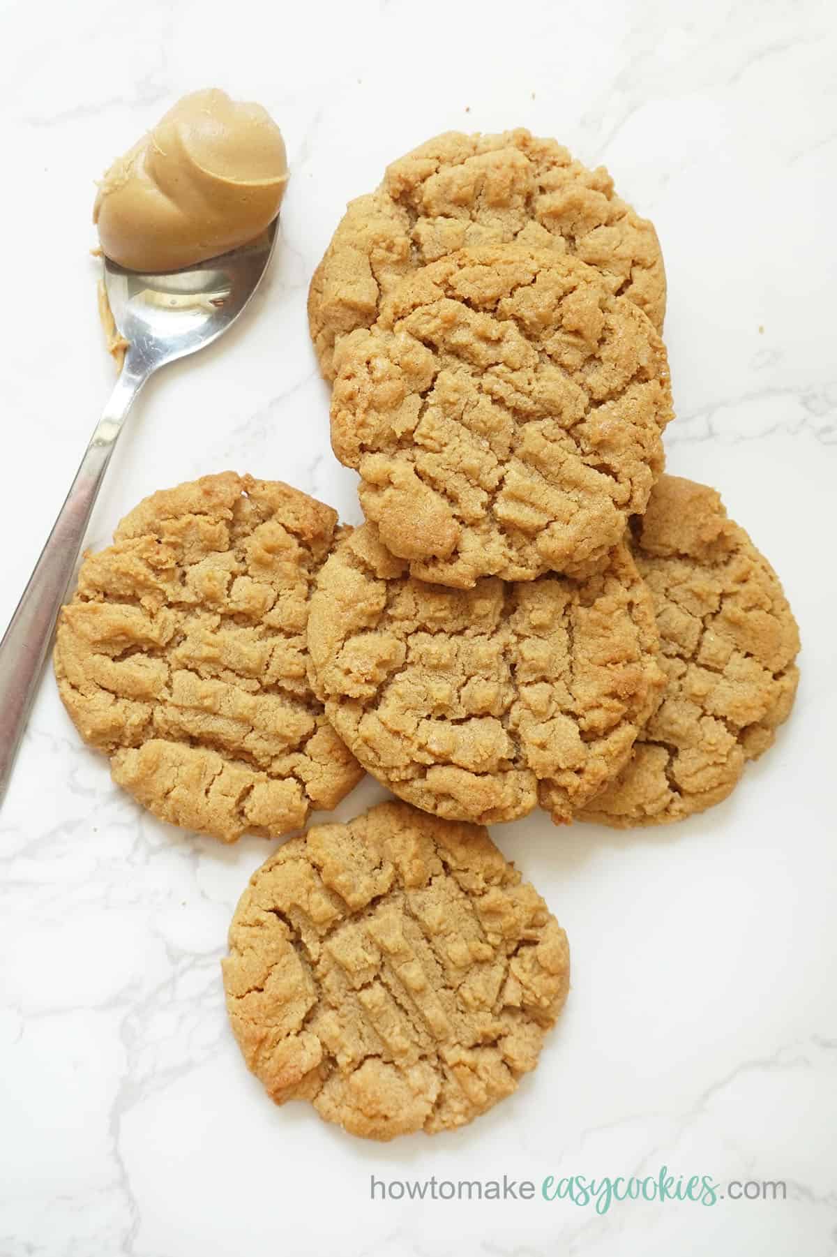 overhead view of flourless peanut butter cookies with spoon of peanut butter