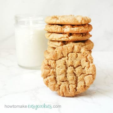 stacked peanut butter cookies with glass of milk