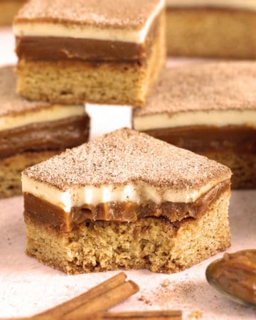 gooey caramel snickerdoodle bars made using a cake mix are topped with a layer of dulce de leche and white chocolate ganache