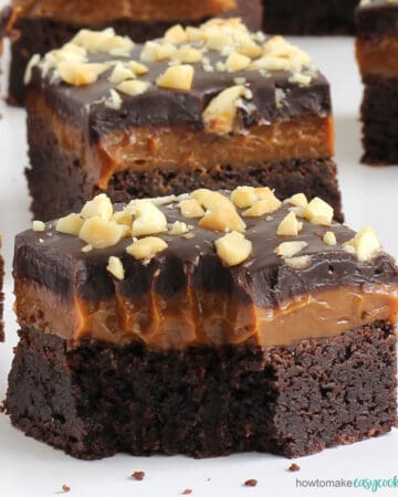 chocolate caramel cookie bars topped with dulce de leche, chocolate ganache, and peanuts