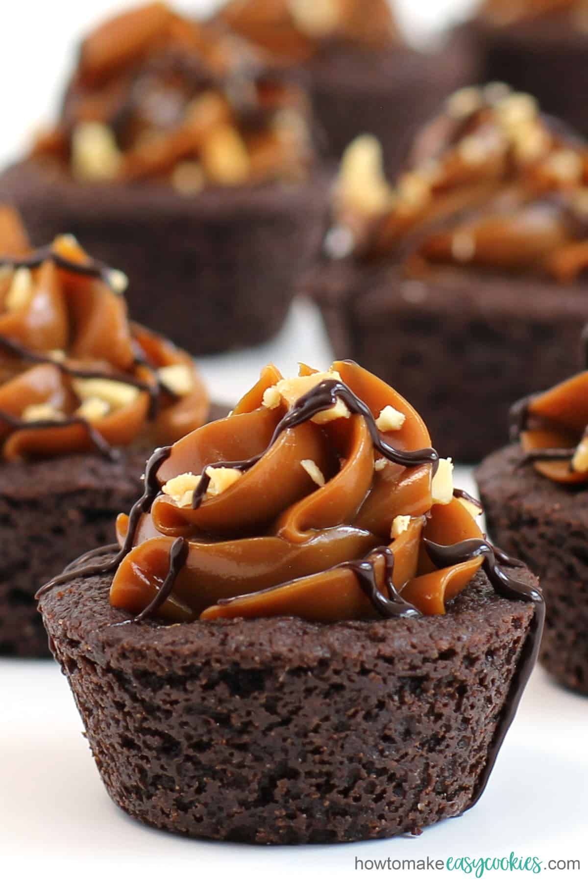 chocolate caramel cookie cups topped with Dulce de Leche, peanuts, and chocolate