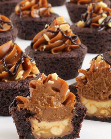 caramel chocolate Snickers cookie cups with Snickers candy bars in the middle