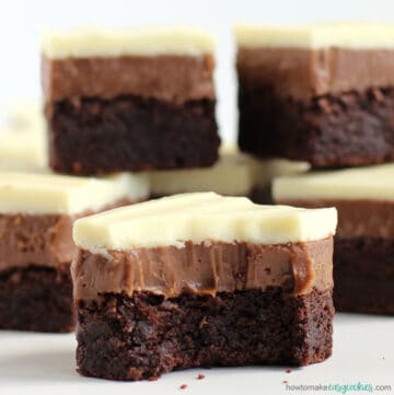 triple chocolate cookie bars topped with milk chocolate and white chocolate ganache