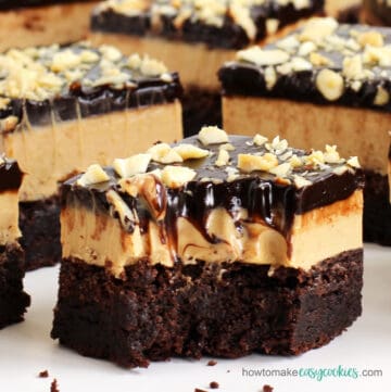 chocolate peanut butter cookie bars topped with peanut butter fudge, chocolate ganache, and peanuts
