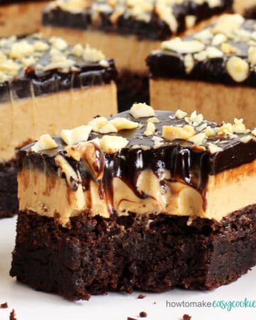 chocolate peanut butter cookie bars topped with peanut butter fudge, chocolate ganache, and peanuts