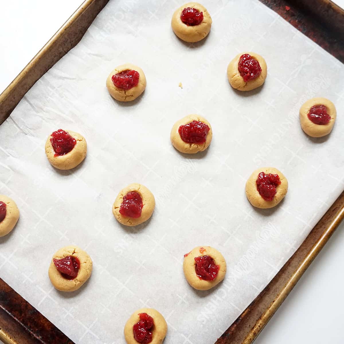 raspberry jelly and peanut butter cookies on baking tray