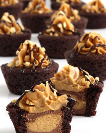 Reese's peanut butter cookie cups stuffed with a Reese's cup and topped with peanut butter, chocolate sauce, and peanuts