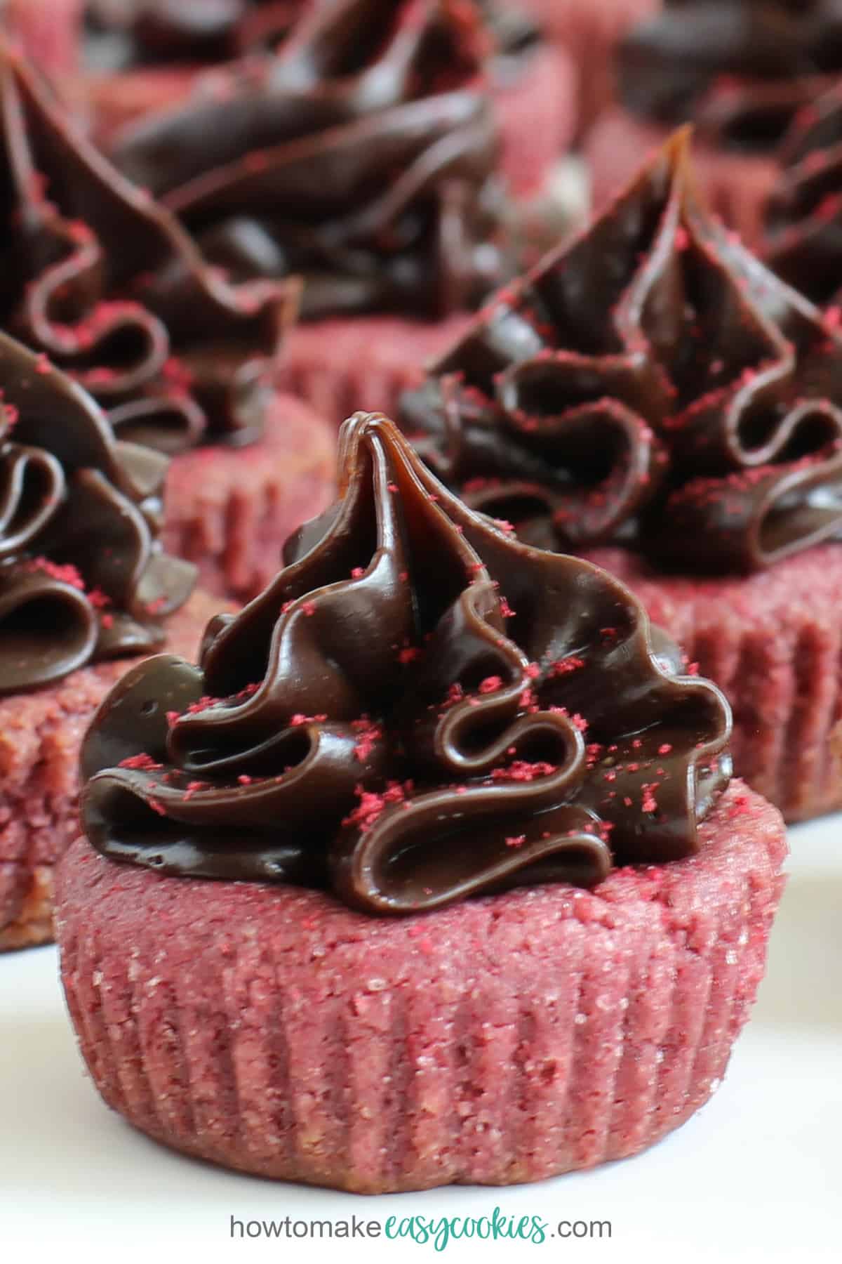 chocolate raspberry cookie cups with raspberry cookie topped with chocolate ganache frosting