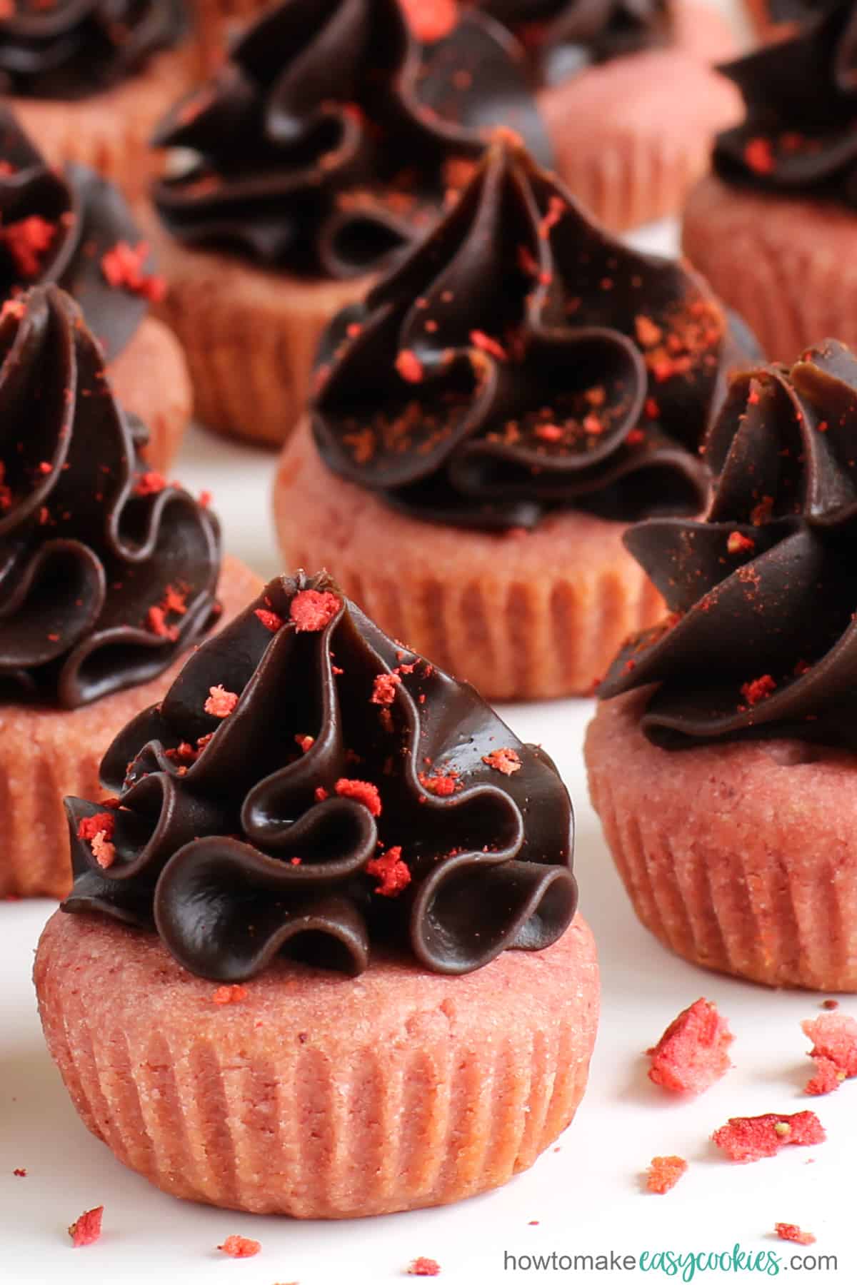 chocolate strawberry cookie cups topped with chocolate ganache and crushed freeze-dried strawberries
