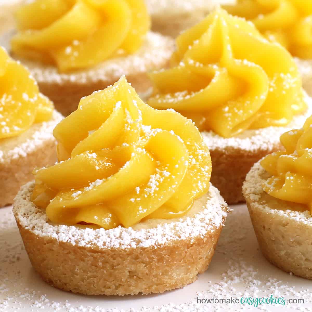 easy lemon bar cookie cups topped with lemon curd and powdered sugar
