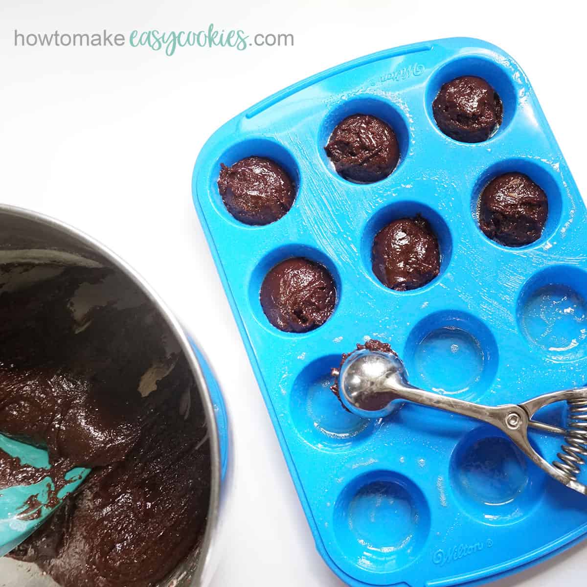scooping chocolate cookie cups into mini muffin pan