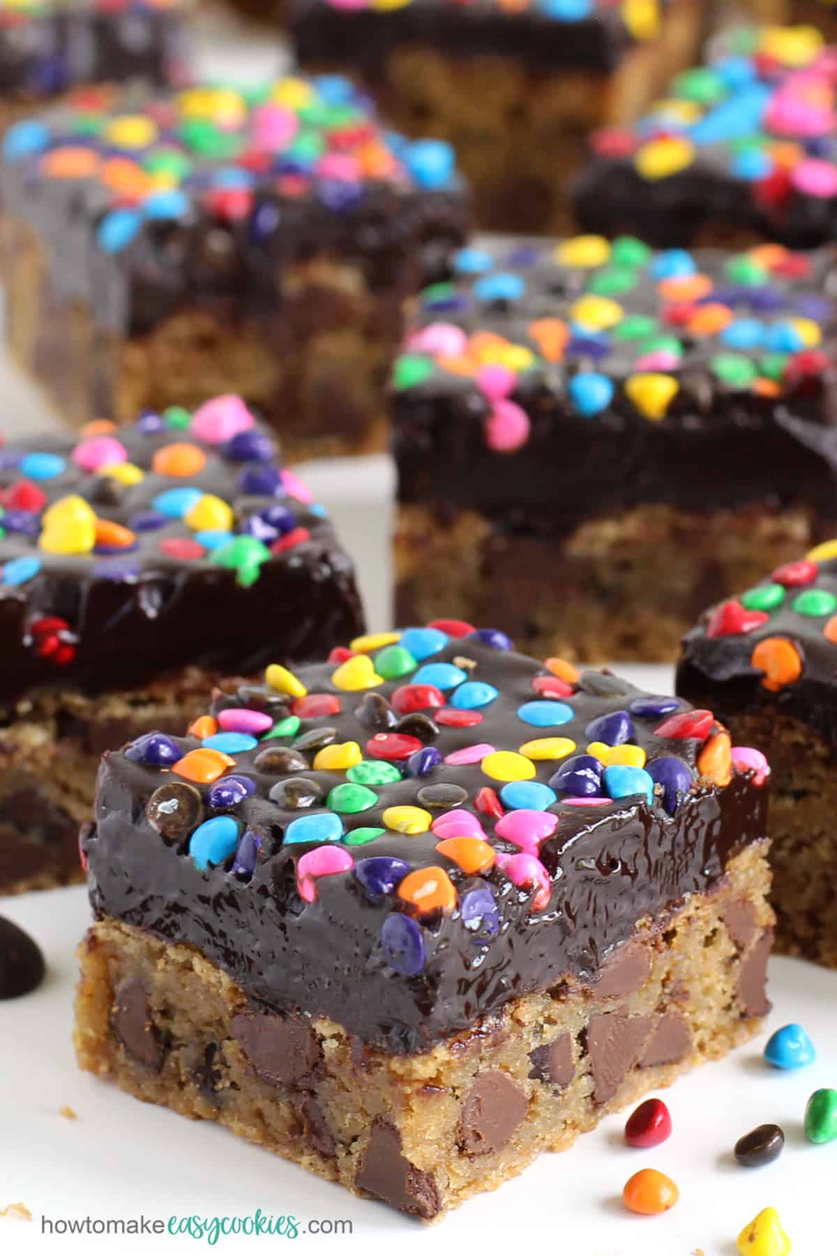 chocolate ganache frosted chocolate chip cookie bars with rainbow chips