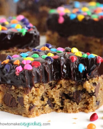 chocolate chip cookie bars frosted with chocolate ganache topped with rainbow chips