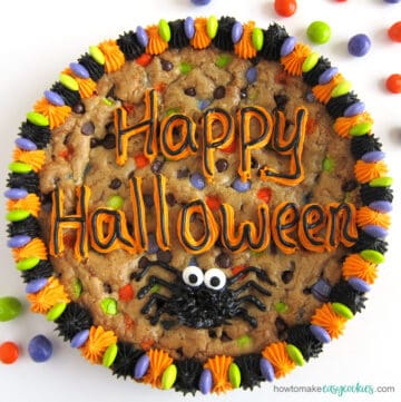 Halloween chocolate chip cookie cake decorated with "happy Halloween" and a spider
