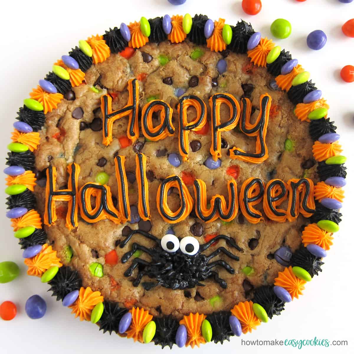 Halloween chocolate chip cookie cake decorated with "happy Halloween" and a spider