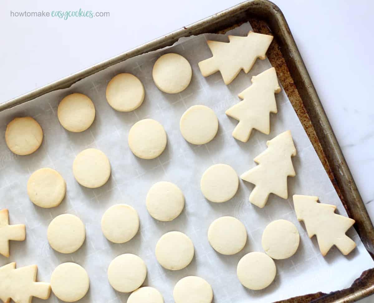 baking tray with cut-out sugar cookies with powdered sugar