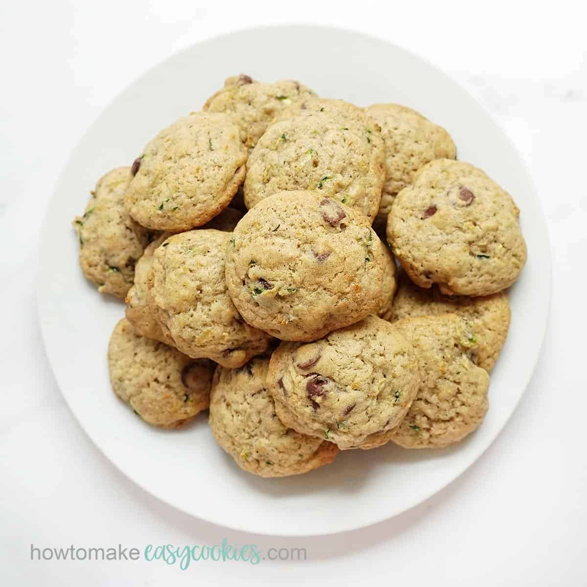zucchini chocolate chip cookies piled on a white plate