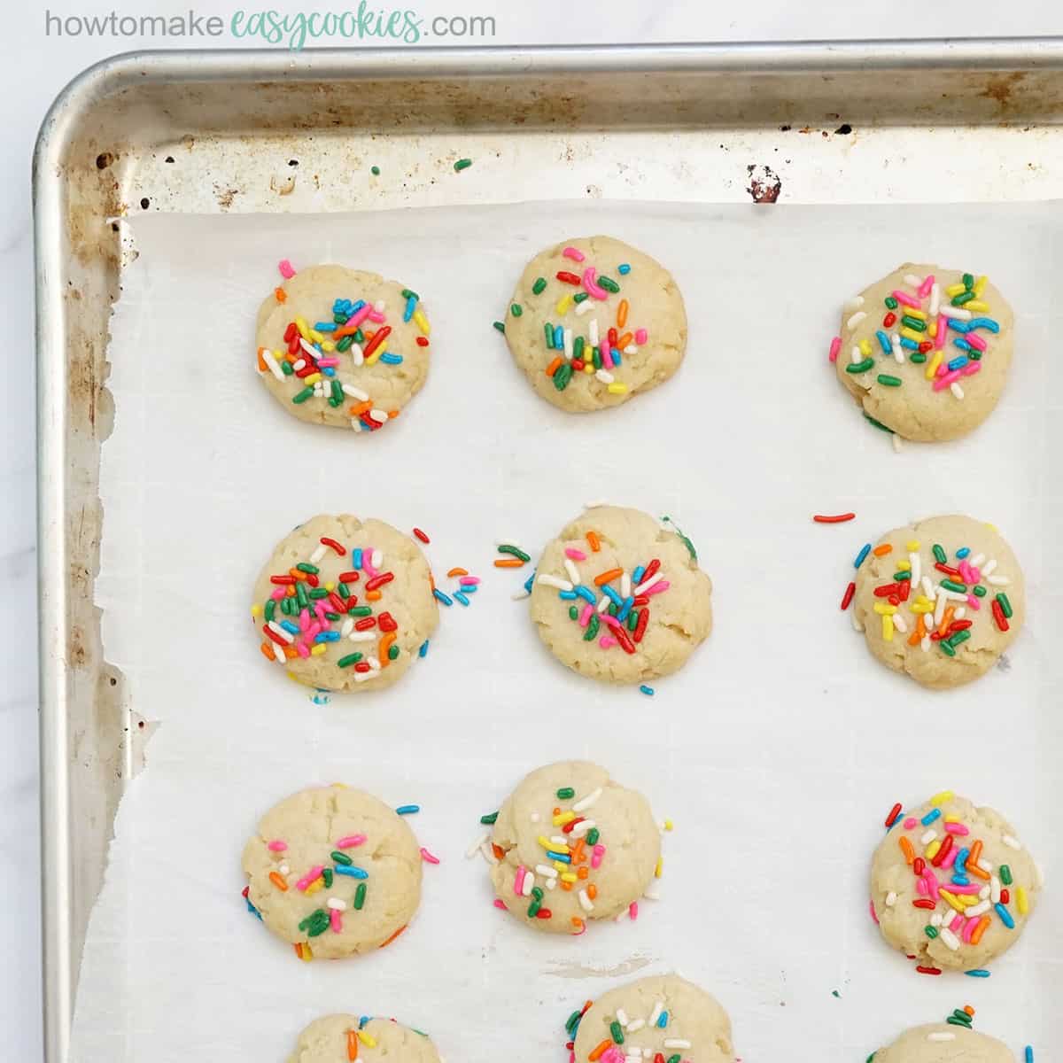 baked sugar cookies with sprinkles on baking tray