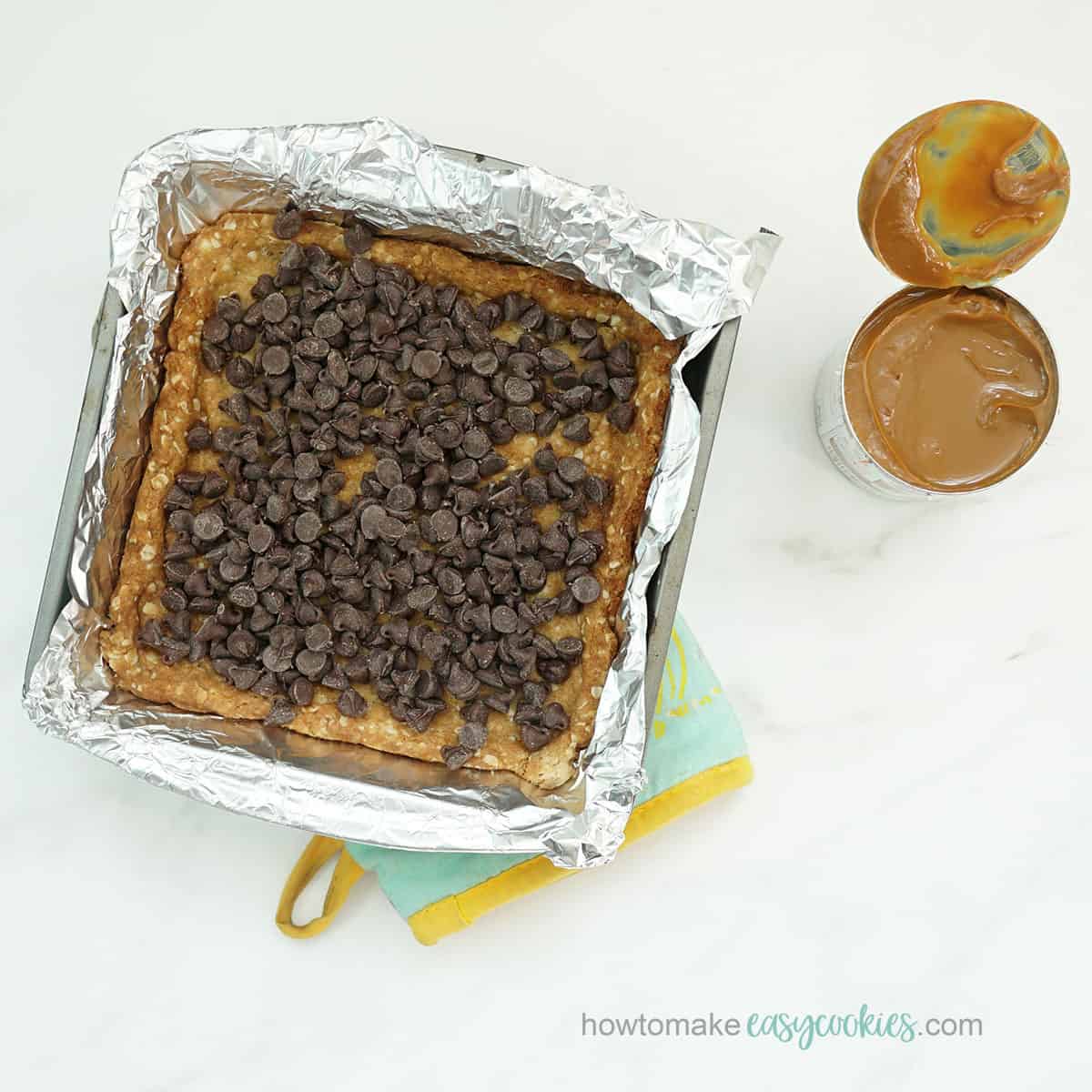 topping oatmeal crust with caramel and chocolate