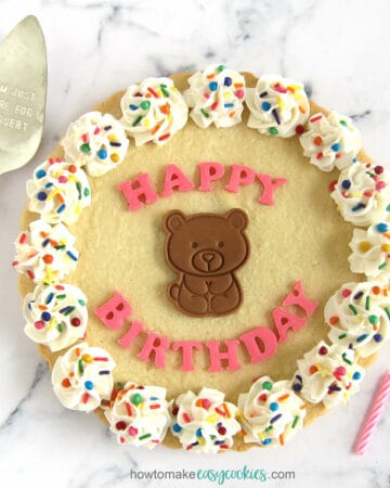 sugar cookie cake with happy birthday letters and a cute chocolate teddy bear