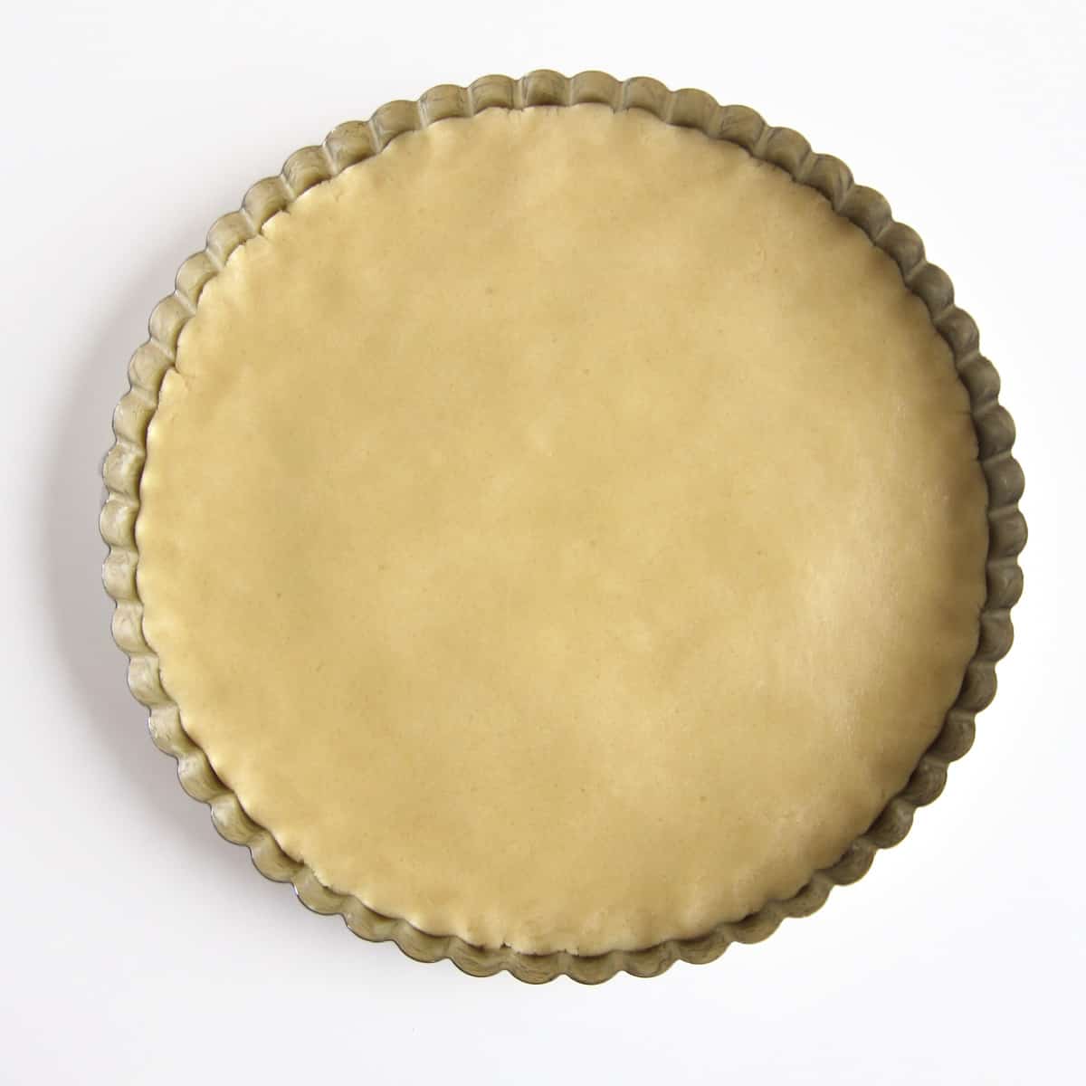 sugar cookie dough pressed into a round cake pan