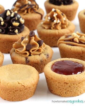 peanut butter cookie cups topped with a variety of ingredients like jelly, peanut butter, and chocolate frosting
