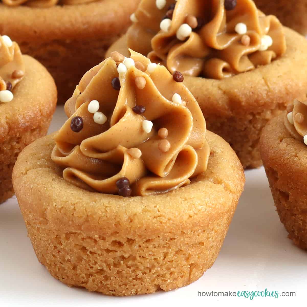 mini peanut butter cookie cups topped with a swirl of creamy peanut butter sprinkled with Mona Lisa chocolate Crispearls