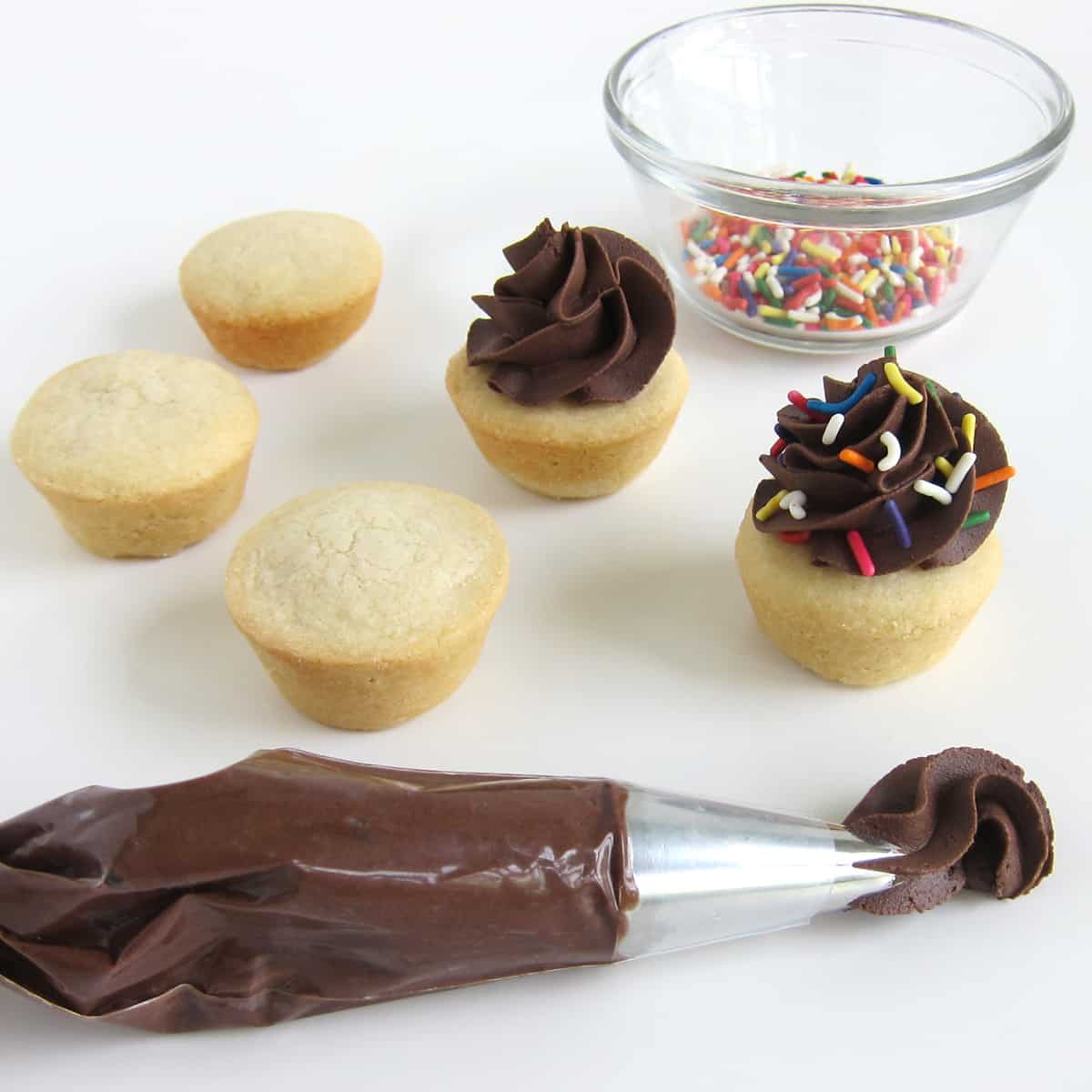 Pipe chocolate frosting on sugar cookie cups then add rainbow sprinkles on top.