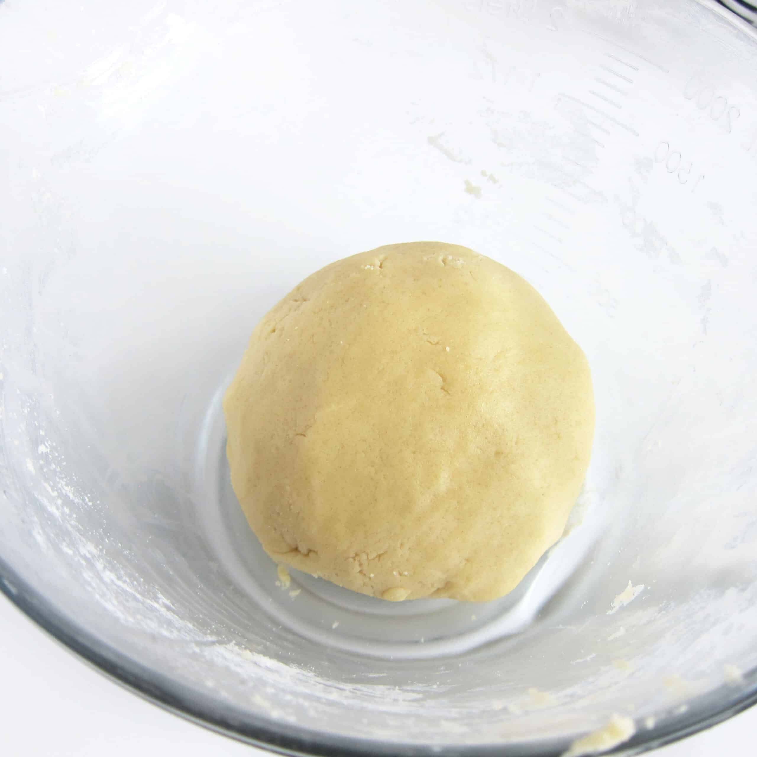 Ball of sugar cookie dough in a mixing bowl.