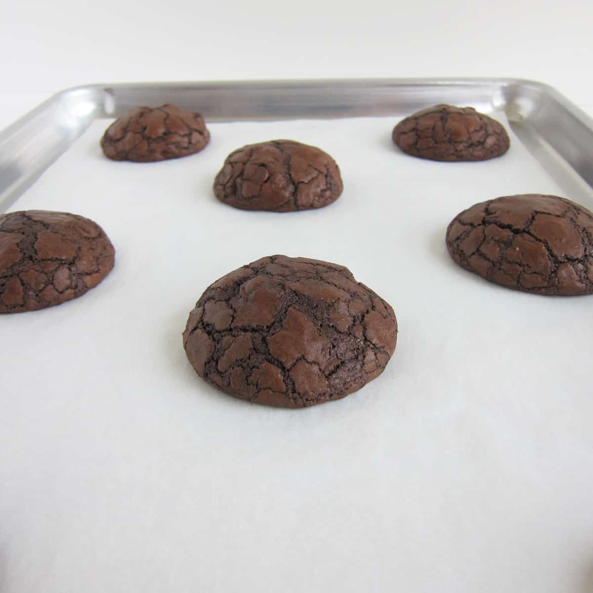 Thick baked brownie mix cookies a parchment paper-lined baking tray.
